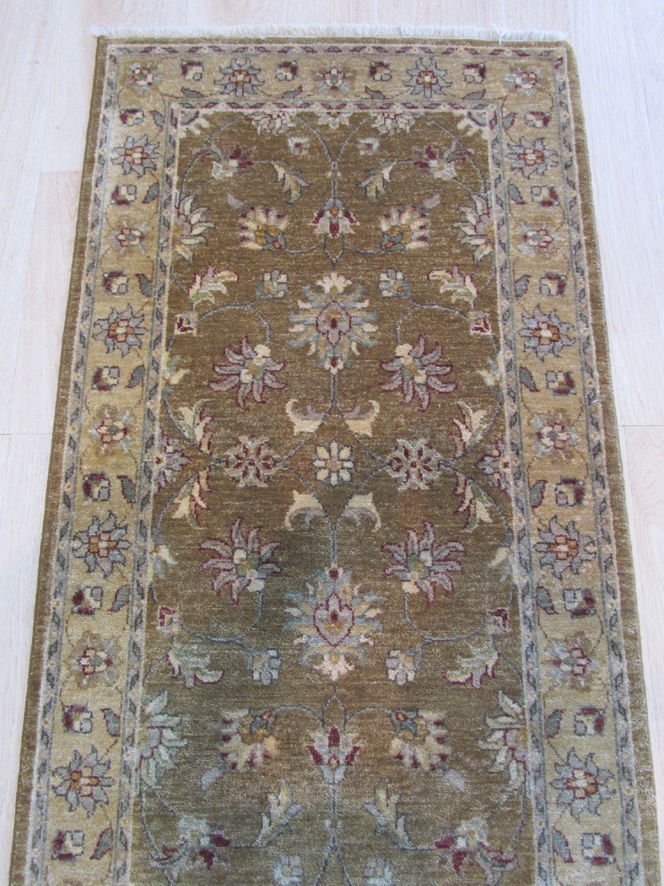 Violet Oriental Beige Hand Knotted Wool Rug, showcasing intricate floral patterns and soft beige tones, adding warmth to a living room setting with a natural light source.