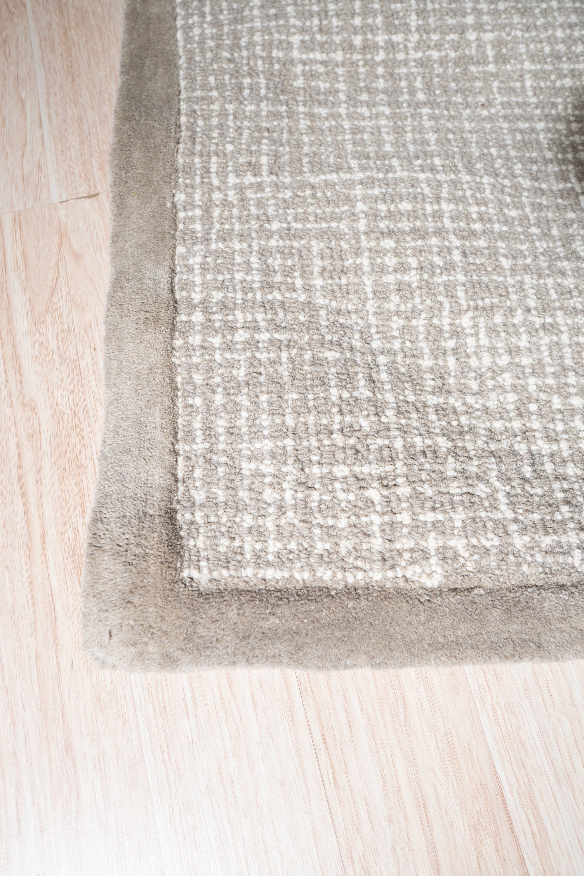 Cozy Willow Brown Hand Tufted Wool Rug, showcasing its warm brown tones and soft texture, laid on a light hardwood floor in a well-lit living room.