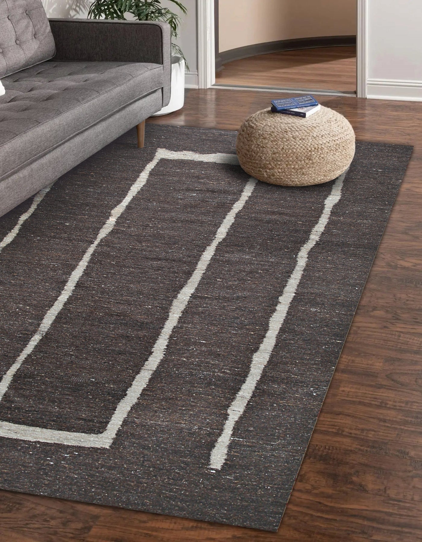 Talia Delicate Brown Flatweave Wool Rug gracing a light-filled living room. Warm brown tones and flatweave texture complement the neutral dÃ©cor. Wool construction visible in the rug's subtle pattern.