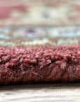 Lydia Vibrant Red Hand Tufted Wool Rug, a bright red wool rug, anchors a living room featuring a modern sofa, patterned throw pillows, and a light-colored coffee table.