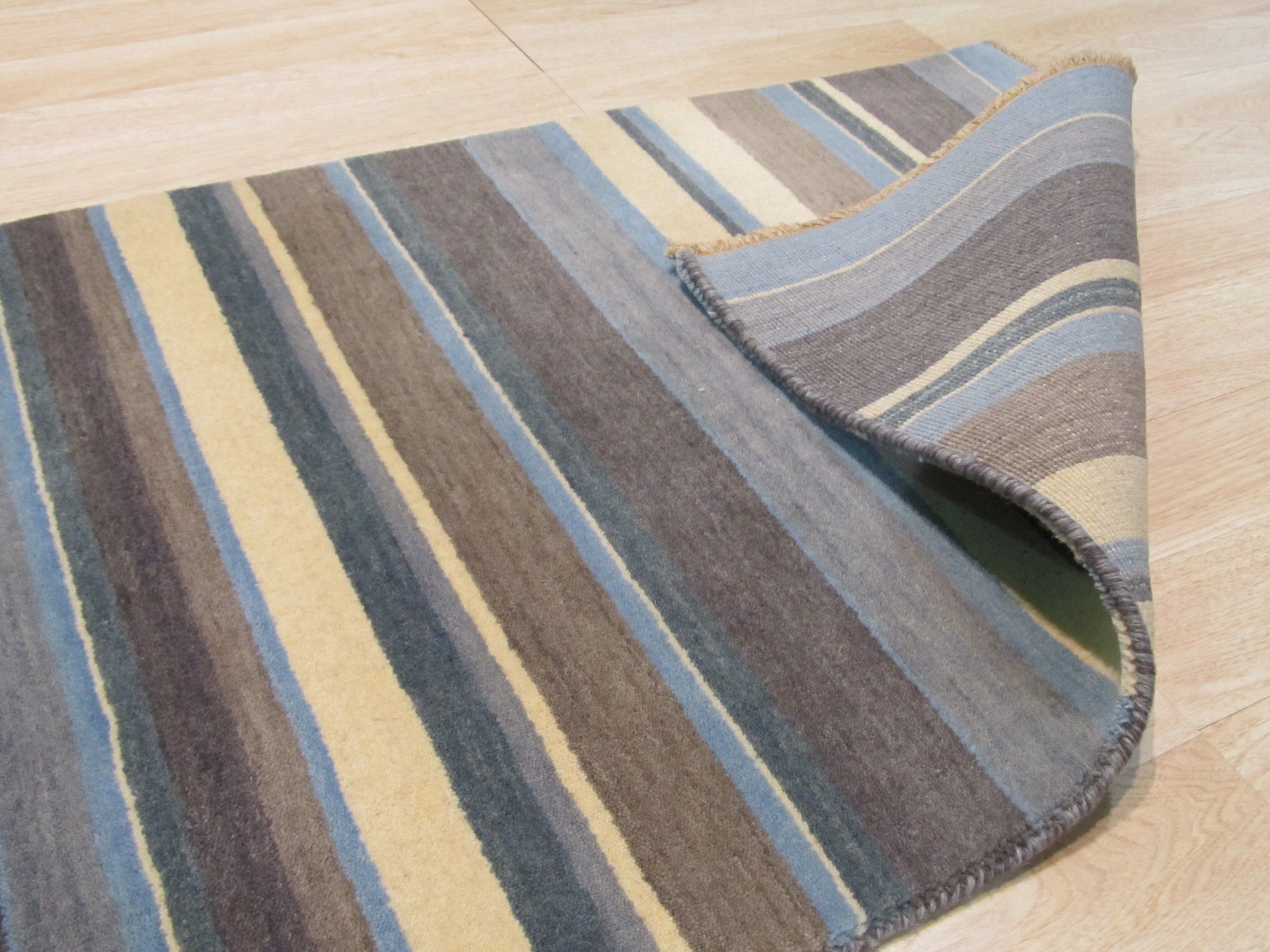 Lila Fiona Multicolor Handmade Wool Rug, displaying vibrant hues and intricate patterns. Warm tones and cool blues interweave across this textured wool rug, creating a visually captivating design.