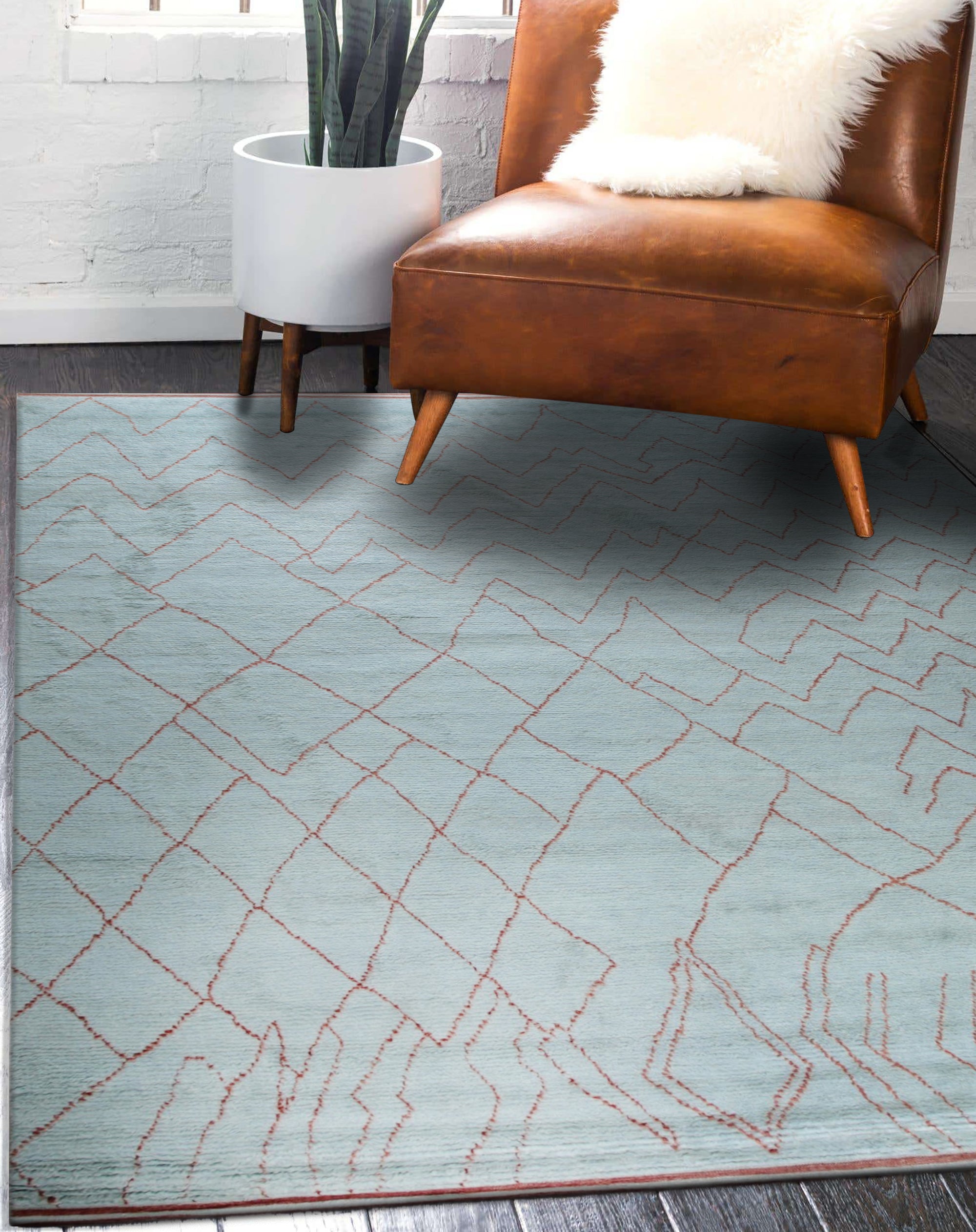 Isla Moroccan Blue Hand Knotted Wool Rug, showcasing its intricate geometric pattern in varying shades of blue and cream, adding a touch of bohemian elegance to a bright, modern living space.