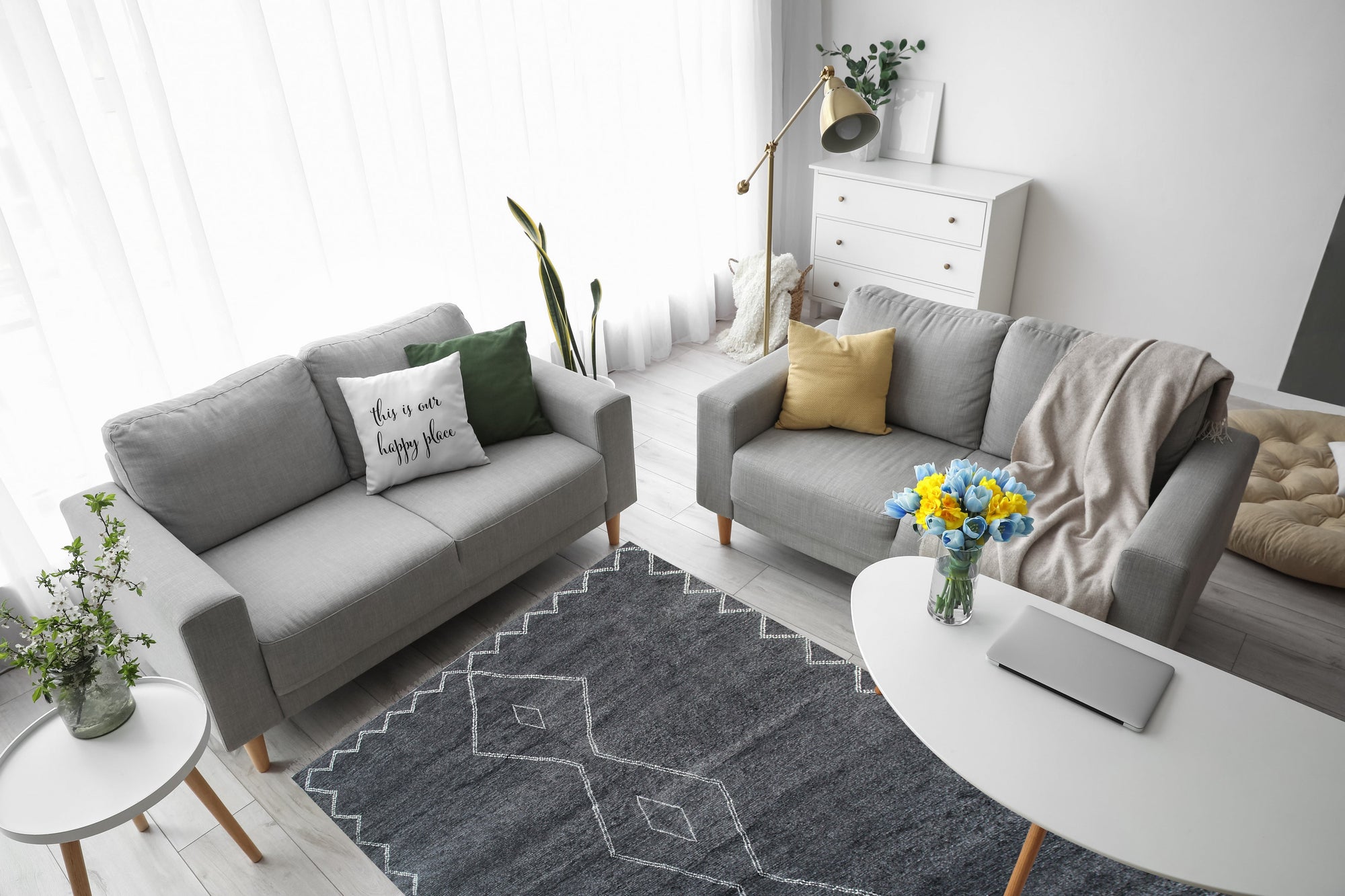 Talia Moroccan Charcoal Hand Knotted Wool Rug, a charcoal hand-knotted wool rug with geometric patterns, displayed in a brightly lit living room setting.