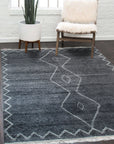 Talia Moroccan Charcoal Hand Knotted Wool Rug, its textured surface and geometric patterns displayed in a bright, naturally lit room, showcasing a subtle blend of charcoal tones and hand-knotted construction.