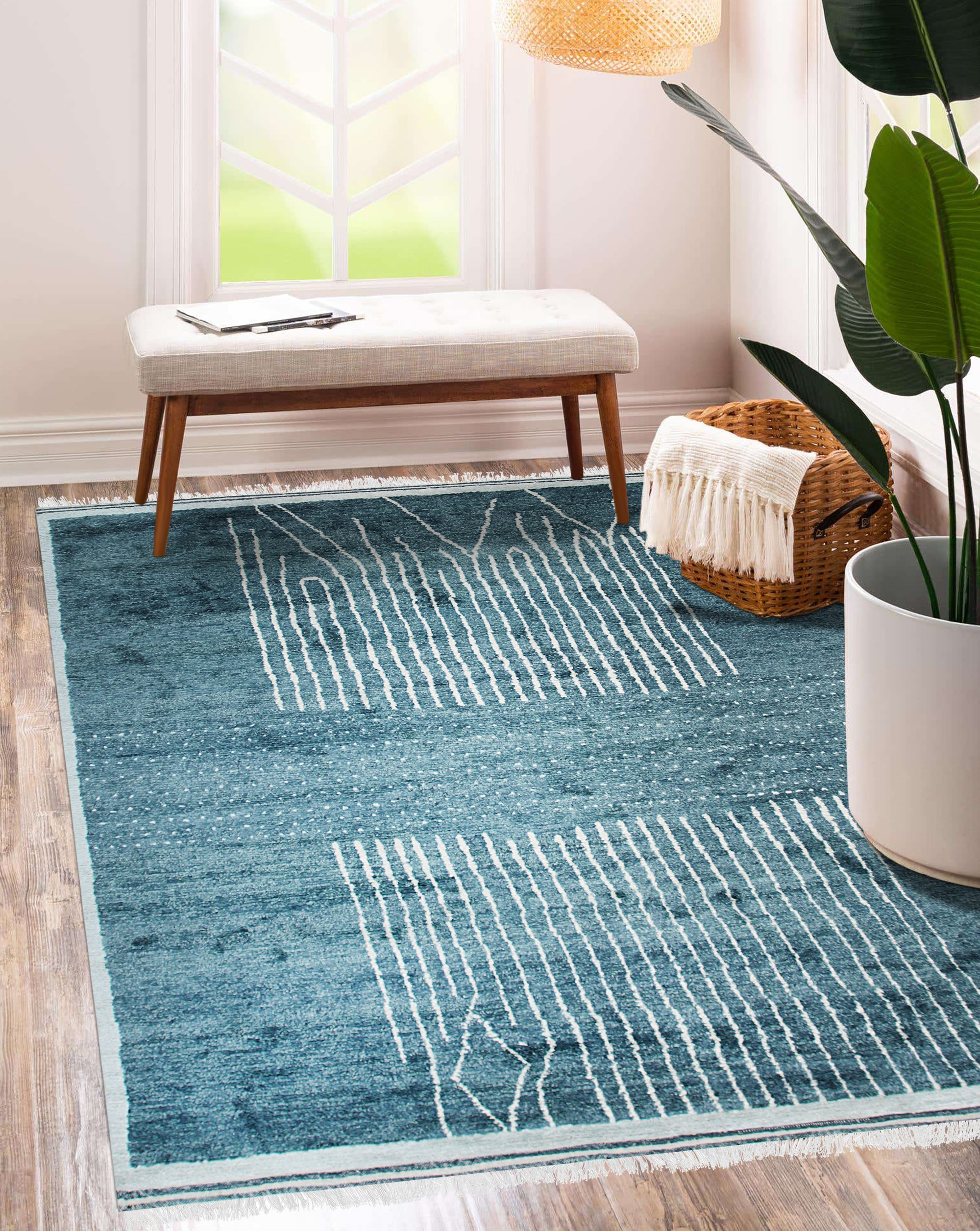 Freya Moroccan Green Hand Knotted Wool Rug, its lush pile a verdant field dotted with subtle, geometric motifs, fills a sunlit room, lending warmth and texture to the modern space.