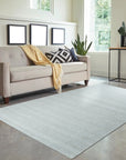 Fiona Rustic Ivory Flatweave Wool Rug, ivory-toned wool rug with subtle texture, lies horizontally on a polished wood floor, showcasing its light, neutral tones and flatweave construction.