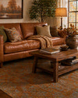 Ruby Inviting Brown Machine Made Wool Rug styled in a cozy living room with caramel leather sofa and warm amber lighting - area rug lifestyle photo