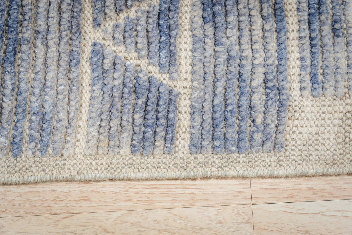 Elegant Marrakech Blue Hand-Knotted Wool Rug, its deep blues and intricate design complementing a bright, contemporary living room setting.