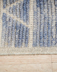 Elegant Marrakech Blue Hand-Knotted Wool Rug, its deep blues and intricate design complementing a bright, contemporary living room setting.