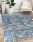 Elegant Marrakech Blue Hand-Knotted Wool Rug, showcasing a deep blue field with intricate geometric patterns, grounding a modern living room with light wood floors and a neutral sofa.