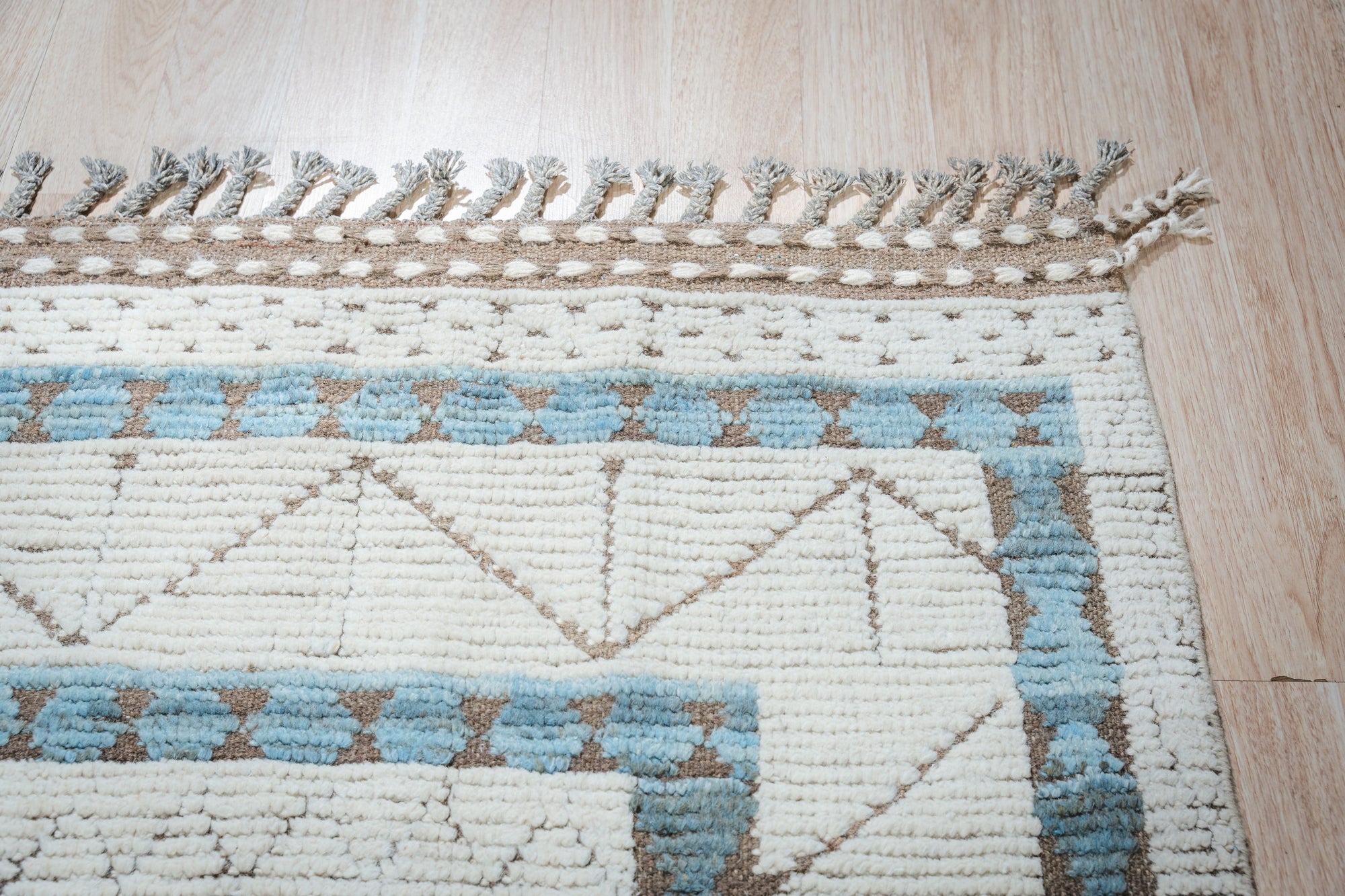 Timeless Marrakech Ivory Hand-Knotted Wool Rug, a warm ivory wool rug with a traditional Moroccan design, shown in a brightly lit living space.