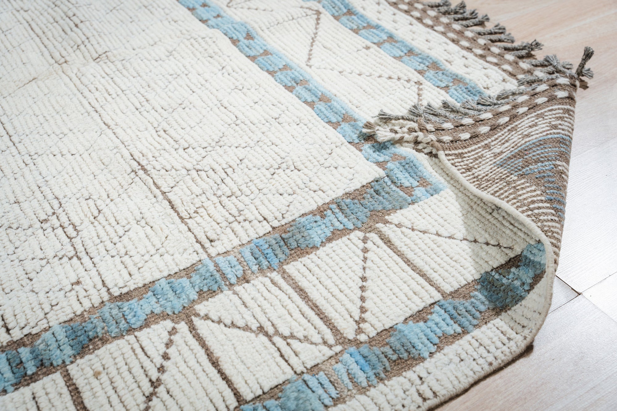 Timeless Marrakech Ivory Hand-Knotted Wool Rug, blending seamlessly into a softly lit living room, its plush ivory pile inviting touch, geometric Moroccan patterns adding subtle depth to the minimalist dÃ©cor.