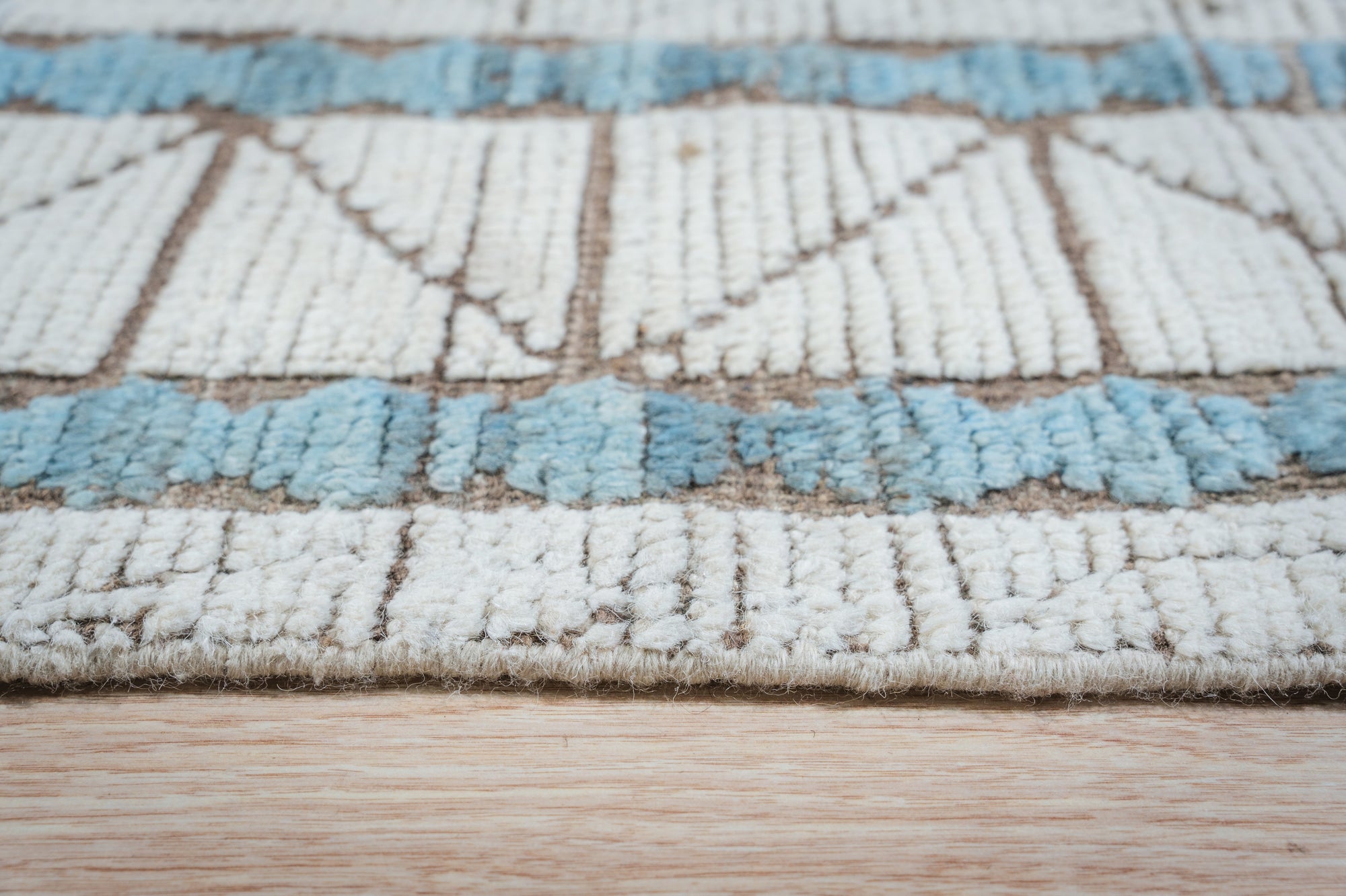 Timeless Marrakech Ivory Hand-Knotted Wool Rug, showcasing a textural, geometric design with subtle variations in ivory, adds warmth to a modern living space.
