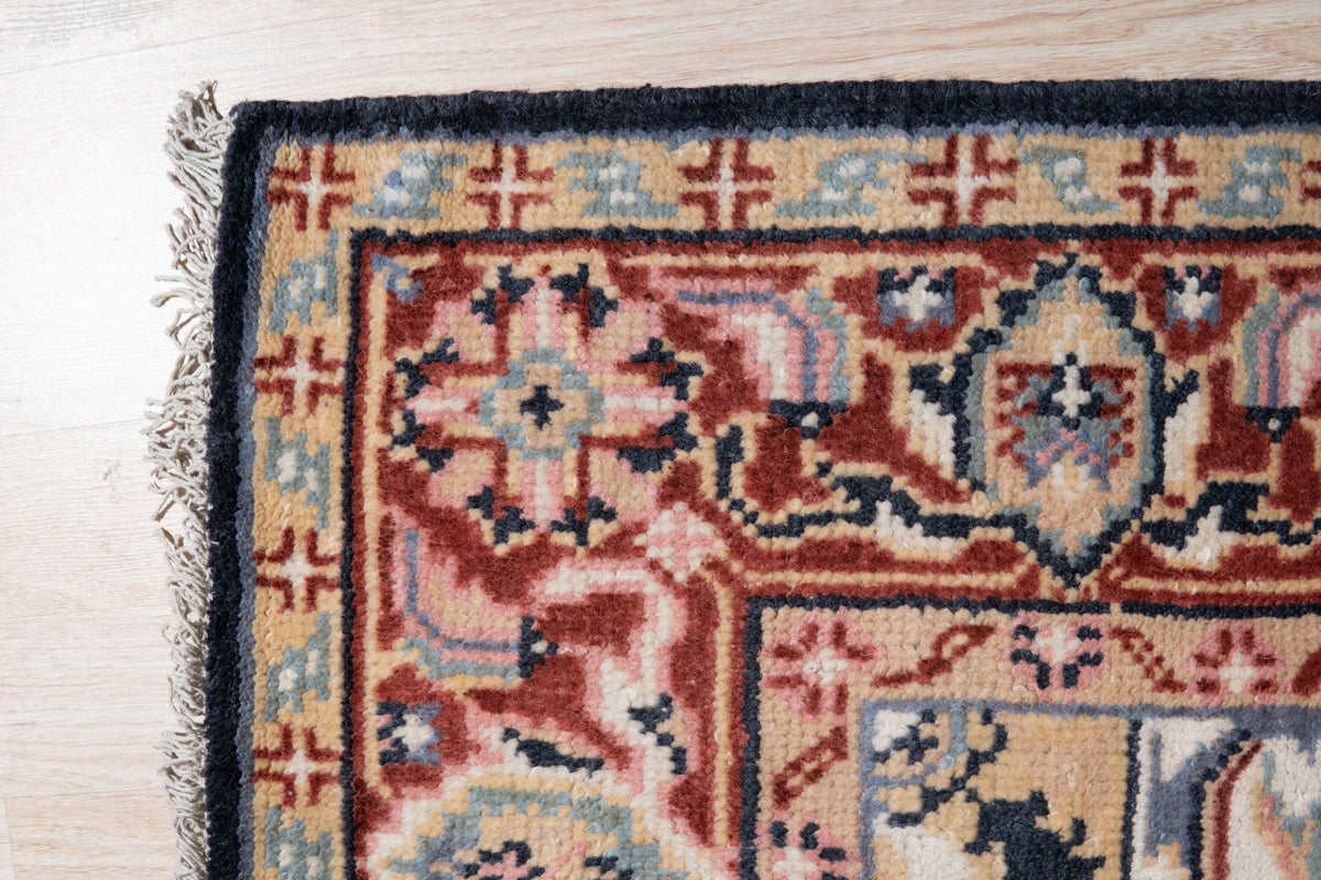 Ella Oriental Navy Hand Knotted Wool Rug, its intricate navy and ivory pattern sprawling across the hand-knotted wool pile, softening a warmly lit interior.
