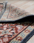 Ella Oriental Navy Hand Knotted Wool Rug, a rich navy and cream wool rug with intricate oriental motifs, lies on a hardwood floor, its hand-knotted texture adding depth and warmth to the setting.