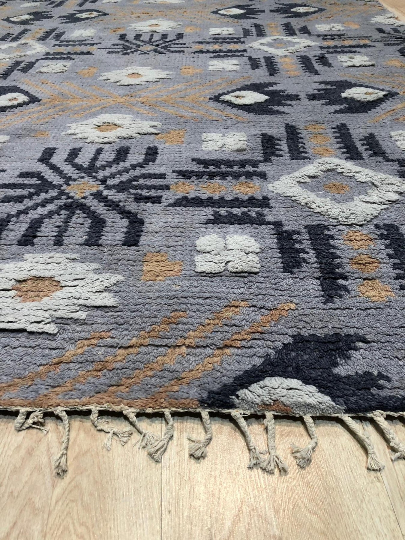 Laine Enchanting Gray Hand Knotted Wool Rug, a sophisticated floor covering in a bright, airy space, its hand-knotted construction evident in the subtle variations of the gray wool.