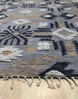 Laine Enchanting Gray Hand Knotted Wool Rug, a sophisticated floor covering in a bright, airy space, its hand-knotted construction evident in the subtle variations of the gray wool.