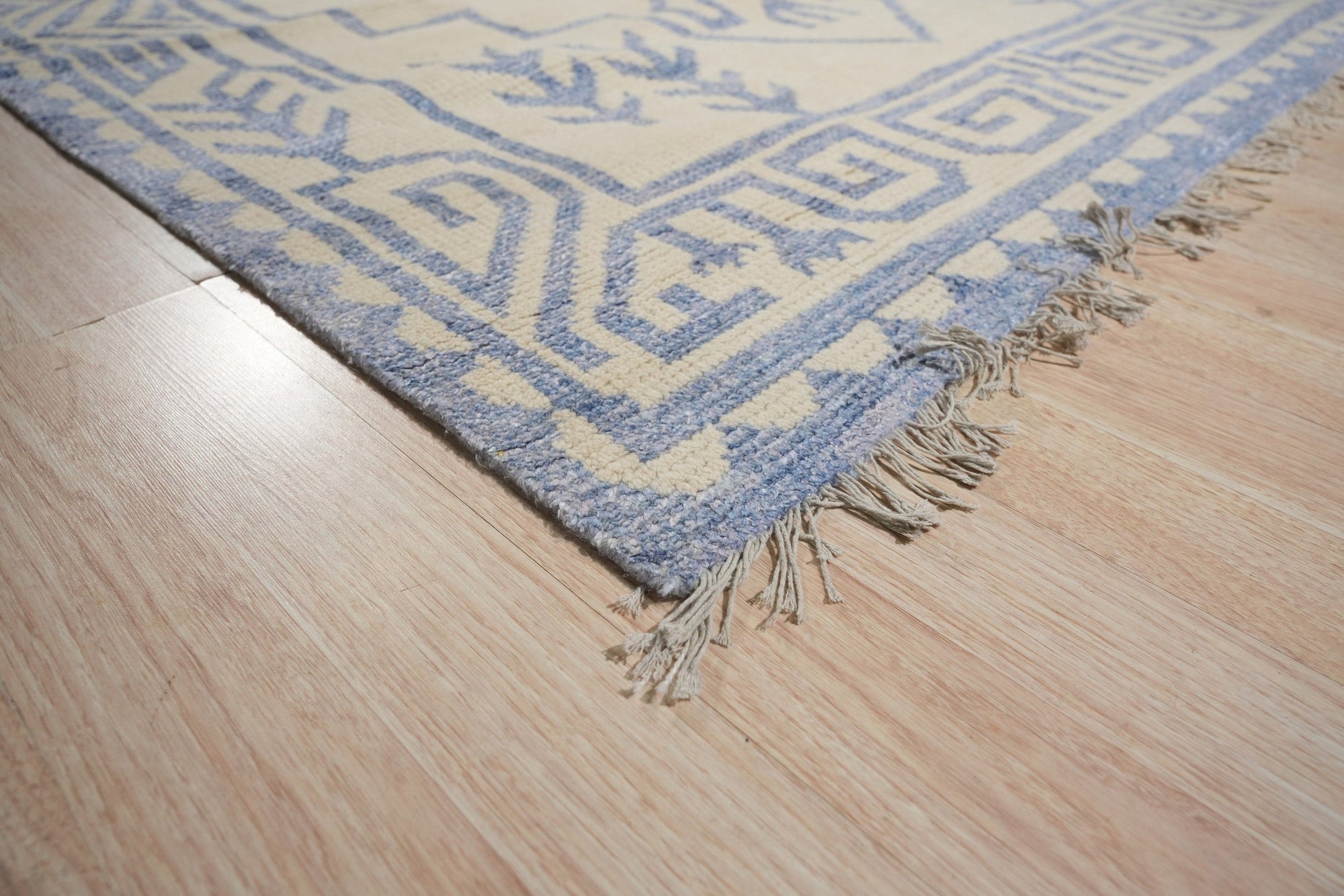 Louie Trara Blue Hand Knotted Wool &amp; Bamboo Silk Rug, its intricate design unfolding in shades of blue and subtle sheen of silk threads, filling a warmly lit living space.