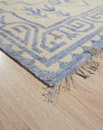 Louie Trara Blue Hand Knotted Wool & Bamboo Silk Rug, its intricate design unfolding in shades of blue and subtle sheen of silk threads, filling a warmly lit living space.