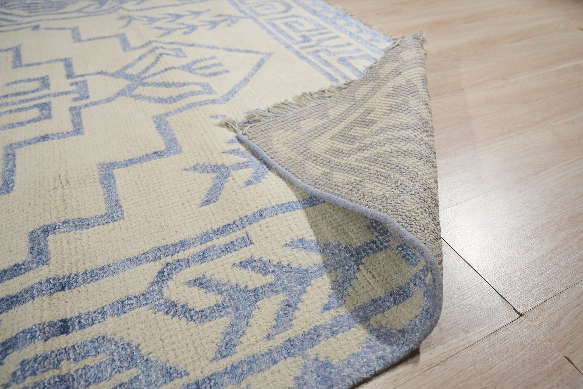 Louie Trara Blue Hand Knotted Wool &amp; Bamboo Silk Rug, its intricate pattern unfolding in shades of blue and subtle sheen, adds textured elegance to a modern living space.