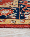 Kira Zinnia Rust Hand Knotted Wool Rug, showcasing a vibrant red hue and hand-knotted construction, displayed in a room setting to demonstrate scale and usage.