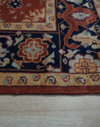 Kira Zinnia Rust Hand Knotted Wool Rug, a vibrant red wool rug with intricate hand-knotted detailing, displayed in a warm, inviting interior setting.