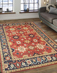 Kira Zinnia Rust Hand Knotted Wool Rug displayed on light hardwood floor, radiating warmth with its vibrant red hues and intricate hand-knotted design.