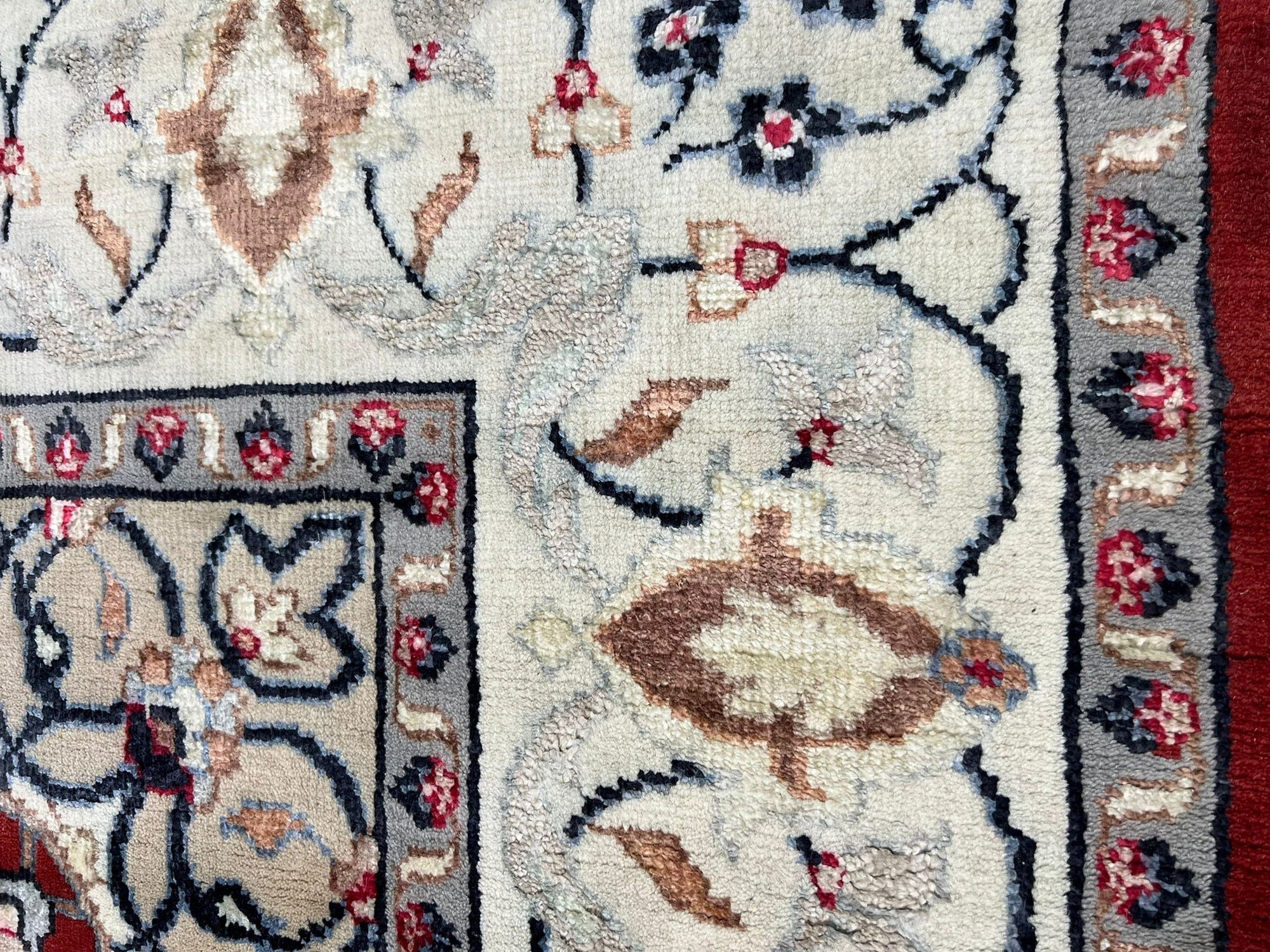 Here&#39;s the alt text for the rug image, following your guidelines:
 
 Selene Trara Red Hand Knotted Wool &amp; Silk Rug, showcasing a complex geometric pattern in vibrant reds, creams, and blues, hand-knotted for exceptional texture and depth on a wooden floor.