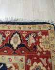 Violet Exquisite Navy Hand Knotted Wool Rug, a plush navy wool rug with a subtle, elegant pattern, softly illuminating a warmly lit interior.