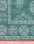 Louie Oriental Turquoise Hand Tufted Wool Rug, its vibrant turquoise hues and intricate oriental design displayed in a room setting, showcasing the rug's soft wool texture.