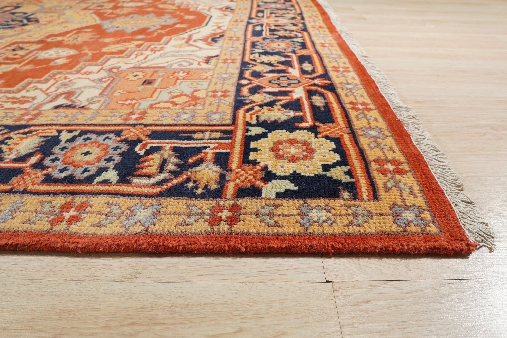 Harlow Oriental Rust Hand Knotted Wool Rug displayed in a bright living room setting; a warm, intricately patterned wool rug anchors the space with rich rust hues and traditional oriental motifs.