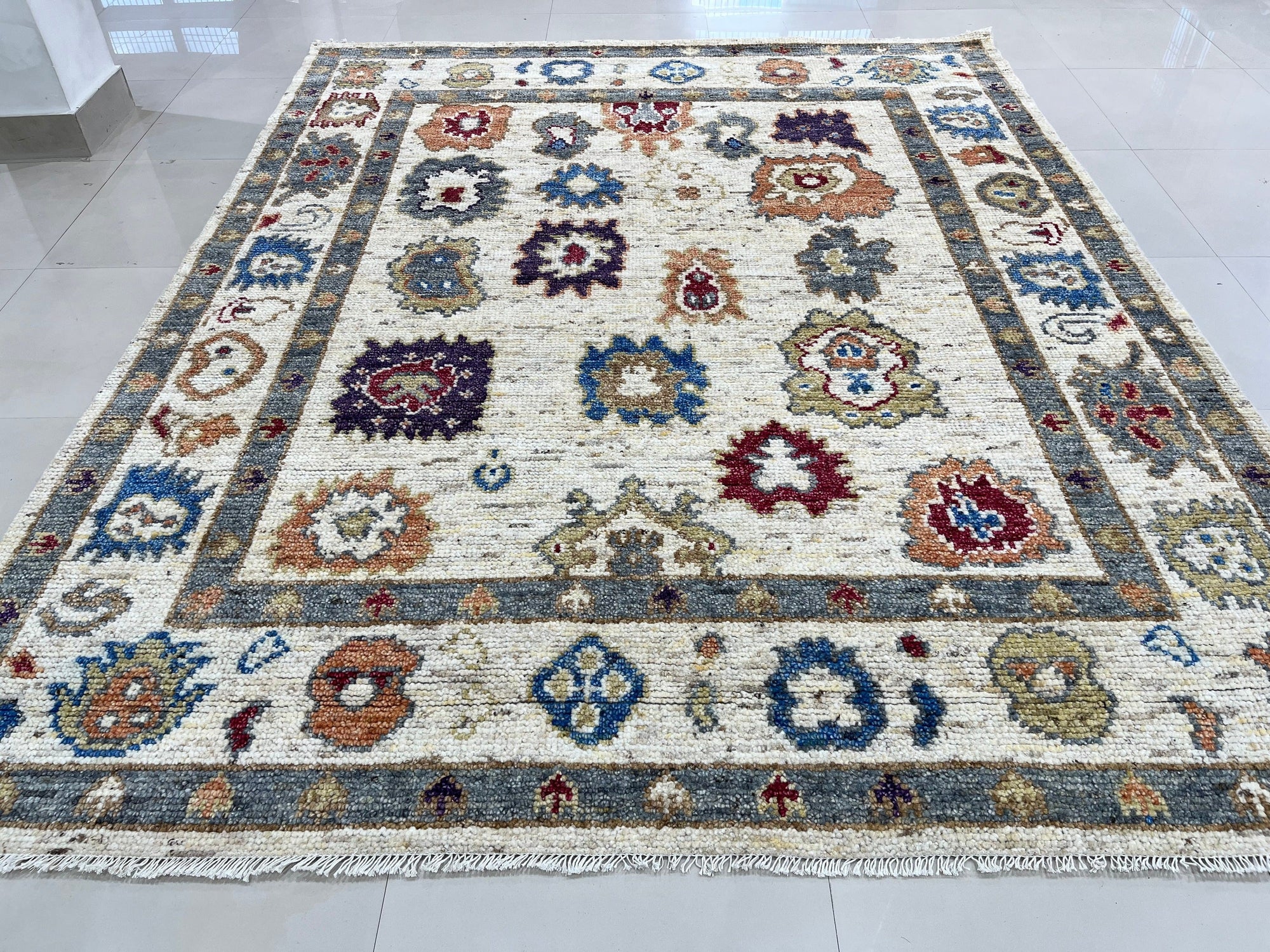 Sumptuous Fiona Ivory Hand Knotted Wool Rug displayed in a styled room; warm, inviting, and showcasing its intricate hand-knotted texture and neutral ivory tones.