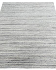 Delicate Striped Silver Handmade Wool Rug, showcasing subtle silver stripes on a textured wool surface, adding understated elegance to a well-lit interior space.