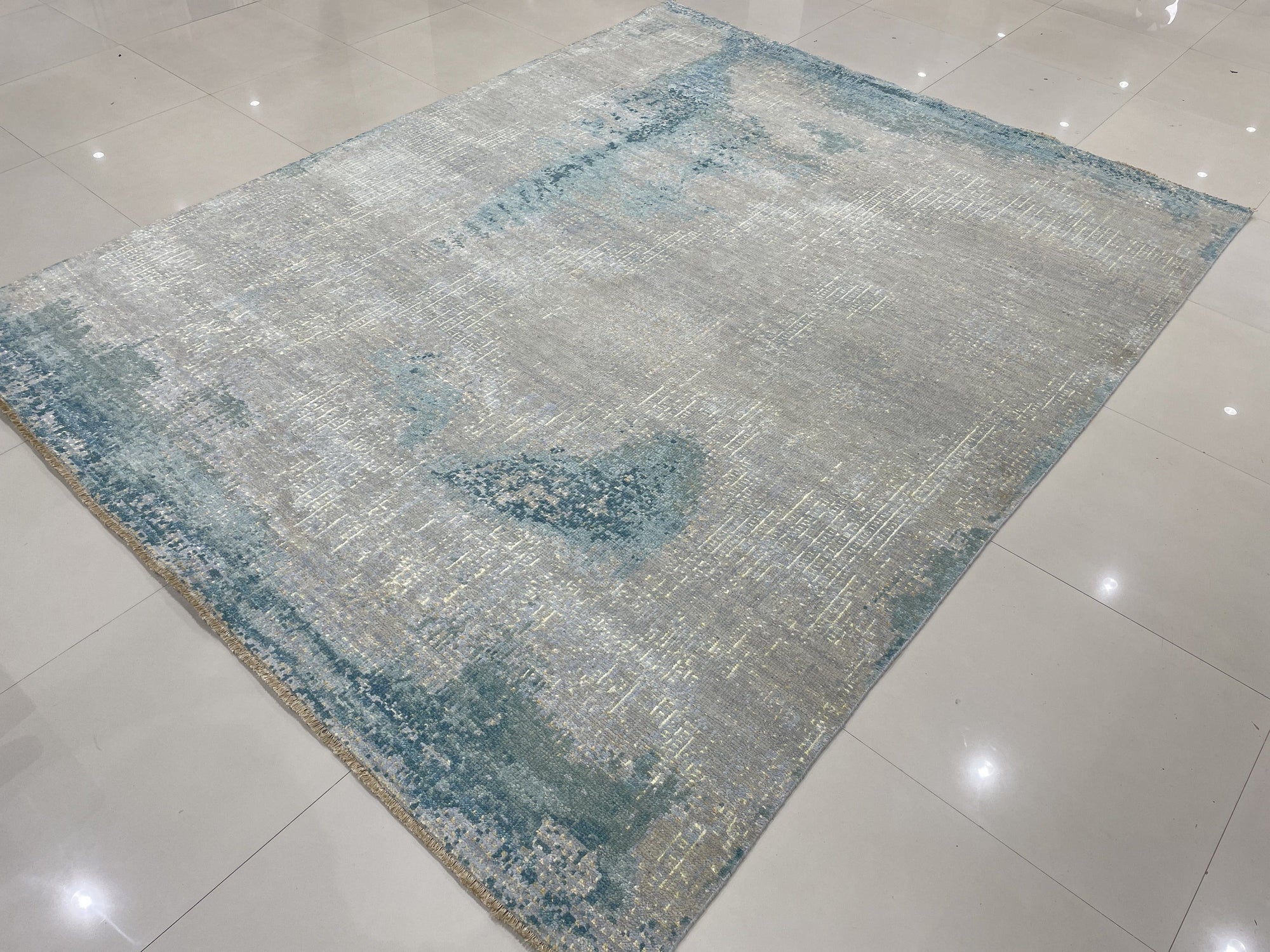 Stylish Sumptuous Aqua Hand Knotted Wool Rug, its deep aqua hues and plush wool texture softening a bright living room, with sunlight highlighting the intricate hand-knotted details.