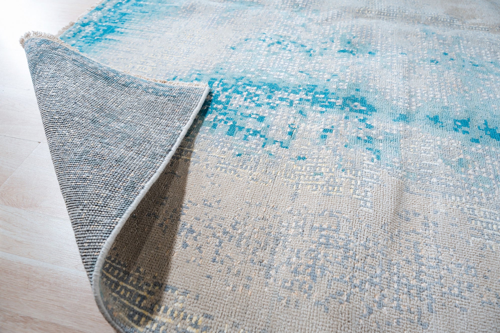 Stylish Sumptuous Aqua Hand Knotted Wool Rug, its soft aqua hues and hand-knotted texture inviting warmth to any space, displayed as part of a larger collection.