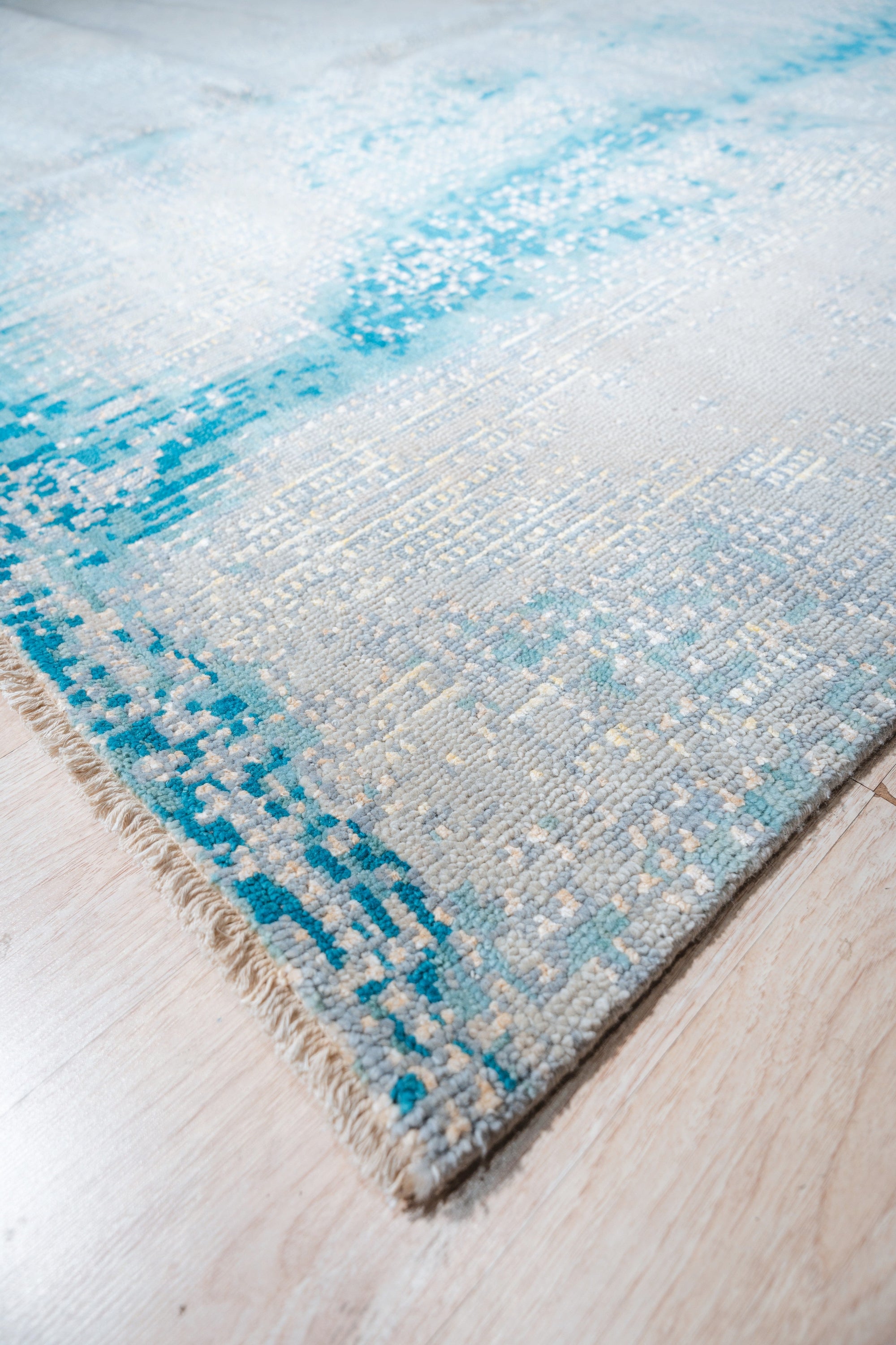 Stylish Sumptuous Aqua Hand Knotted Wool Rug, its cool aqua tones and hand-knotted texture enriching a bright, modern living space with a light wood floor.