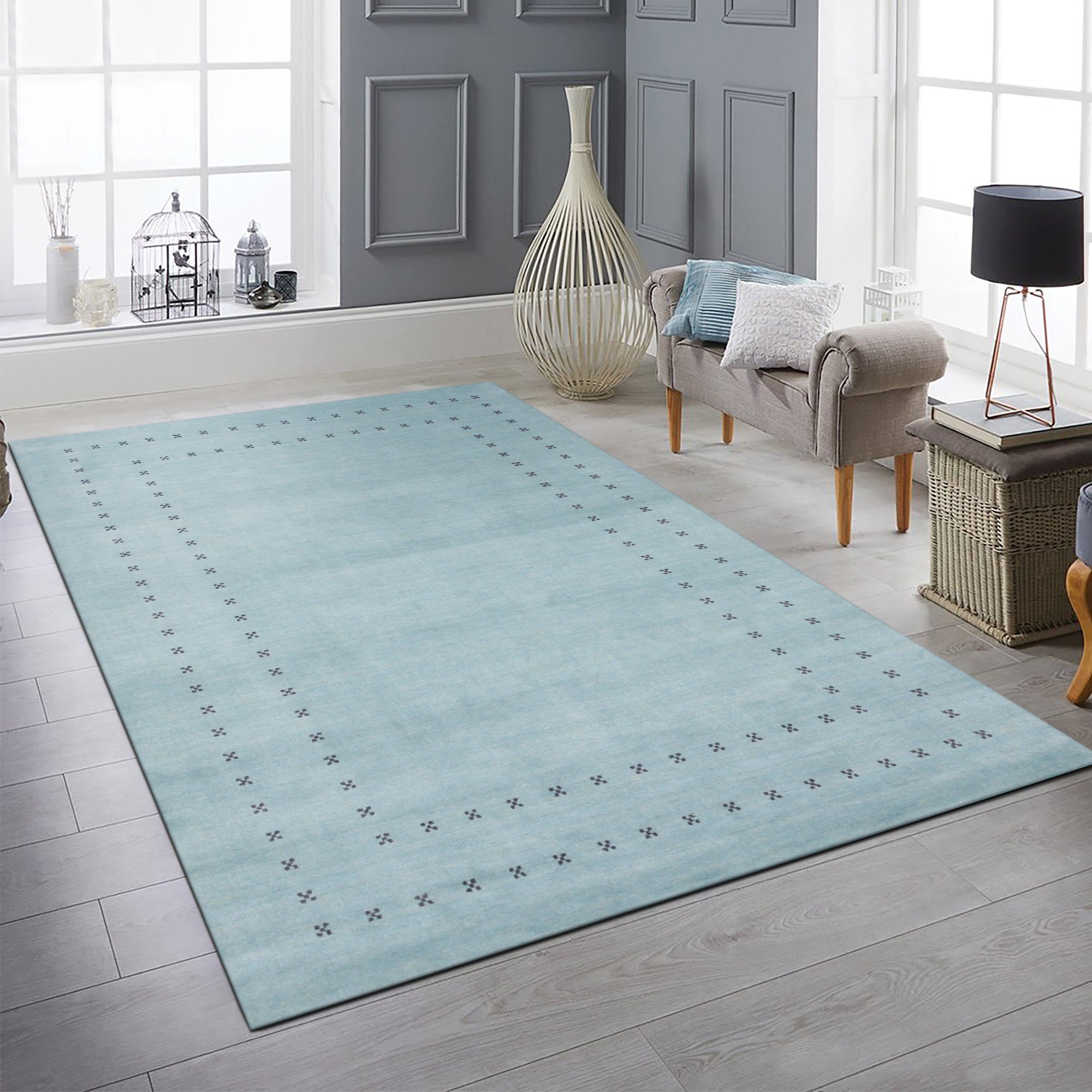 Jasmine Alluring Aqua Handmade Wool Rug, displaying a swirling, abstract pattern of varying aqua hues across its soft wool pile, presented in a bright, modern living room setting.