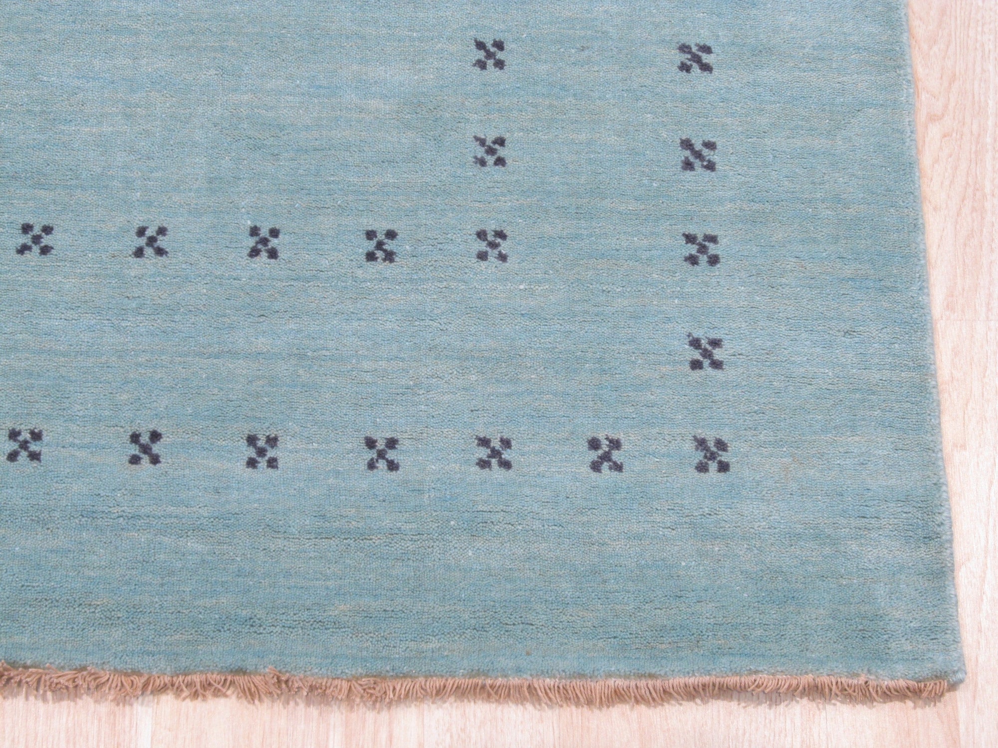 Jasmine Alluring Aqua Handmade Wool Rug, a refreshing accent with its vibrant aqua hues and soft wool texture, lays elegantly in a bright, airy living space.