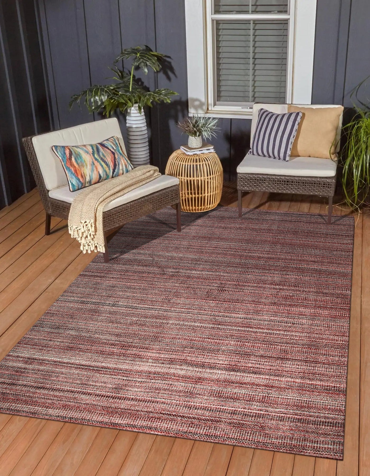 Radiant Elena Red Handmade Wool Rug, a vibrant field of crimson punctuated by intricate, geometric patterns, rests warmly on a polished hardwood floor, inviting comfort and elegance to the room.