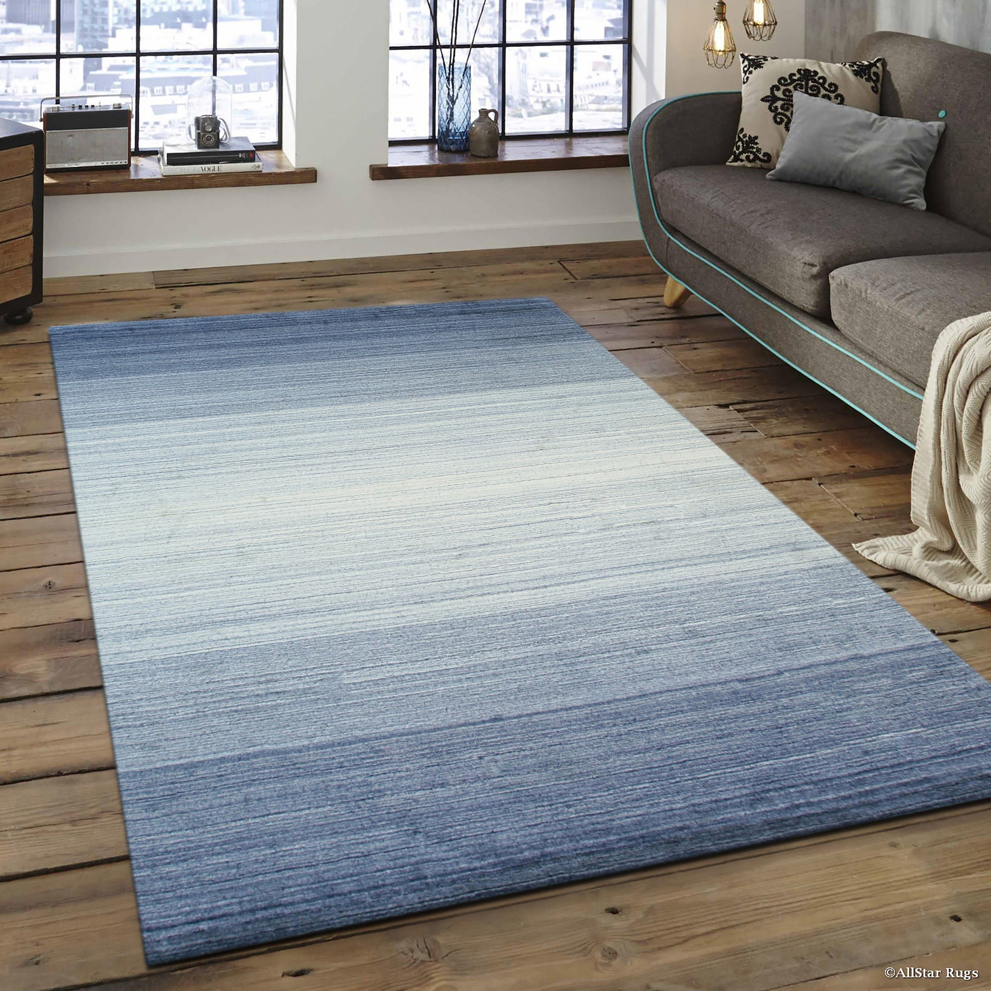 Willow Para Blue Handmade Wool Rug, a calming blend of blues and creams in a textured wool weave, offers a cozy feel underfoot in a brightly lit living space.