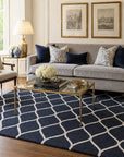 Sloane Willow Navy Hand Tufted Wool area rug styled in a sophisticated living room with grey velvet sofa and brass accents - lifestyle photo