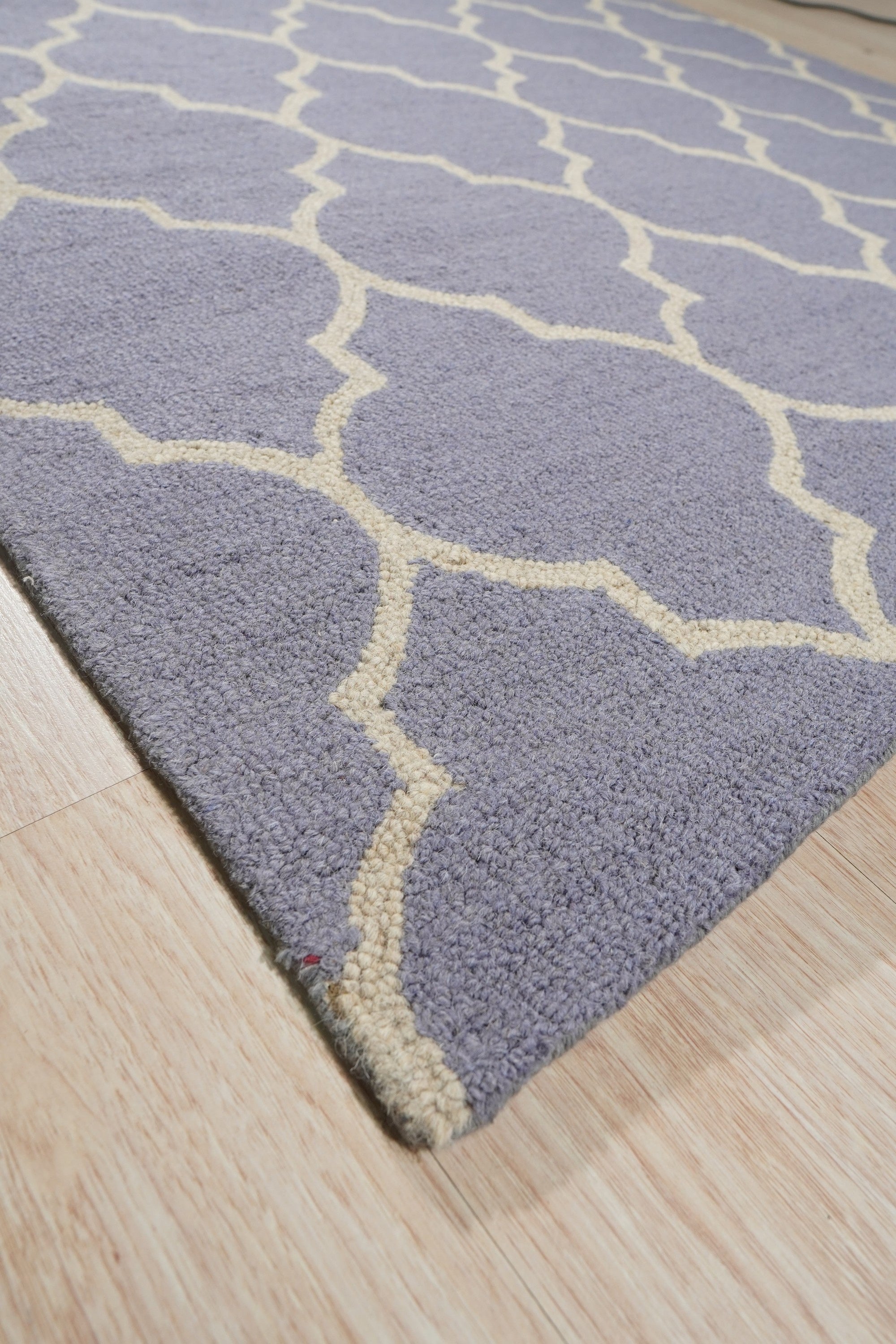 Celia Moroccan Light Purple Hand Tufted Wool Rug, a light purple wool rug with a Moroccan-inspired design, seen in a bright, airy living room.