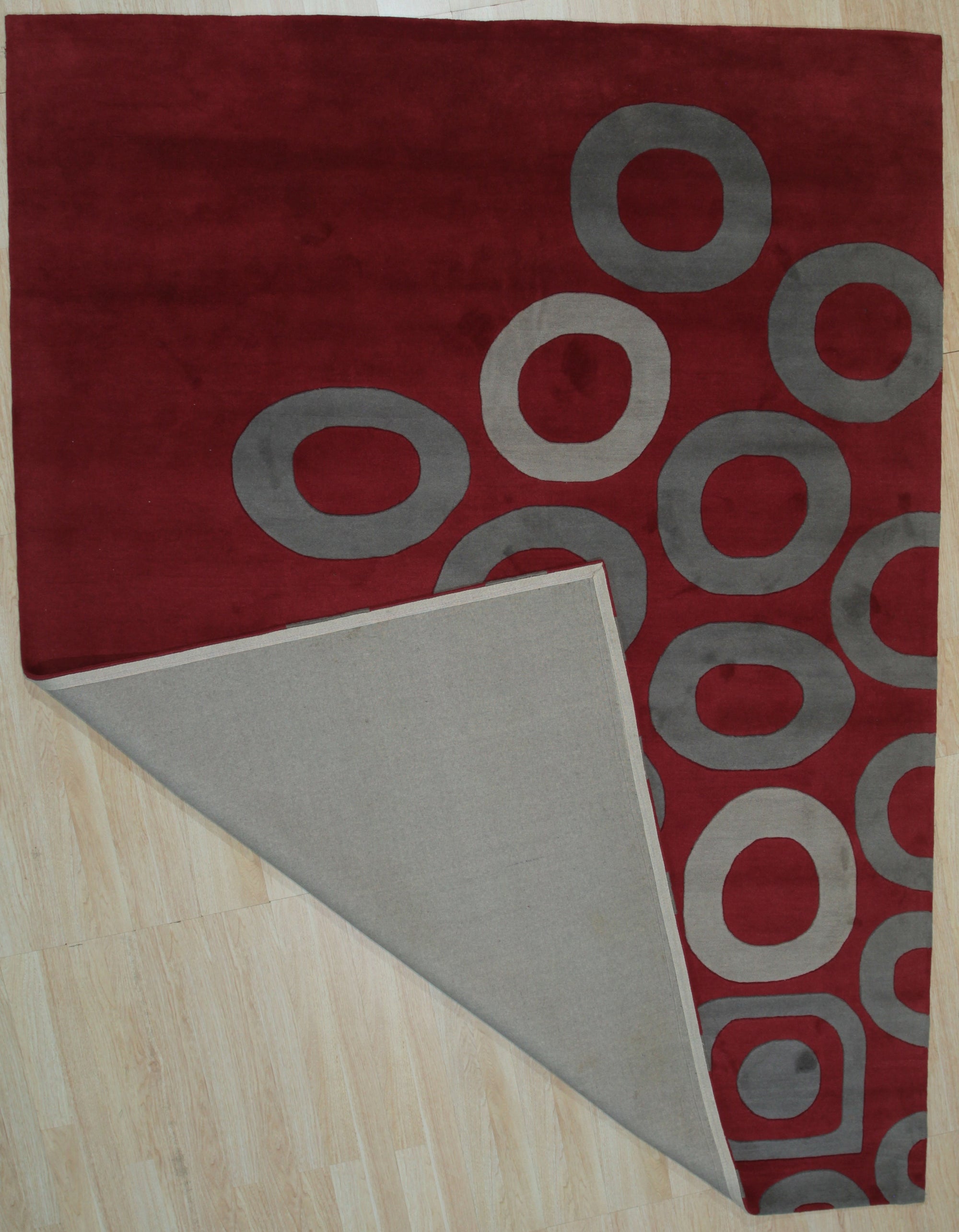 Willow Lila Red Hand Tufted Wool Rug, a vibrant red wool rug with a textured, abstract design, seen in a styled interior setting with coordinating furniture.