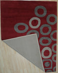 Willow Lila Red Hand Tufted Wool Rug, a vibrant red wool rug with a textured, abstract design, seen in a styled interior setting with coordinating furniture.