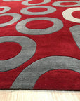 Willow Lila Red Hand Tufted Wool Rug, vibrant red hues and intricate patterns grace this hand-tufted wool rug, bringing warmth and texture to an unseen room.