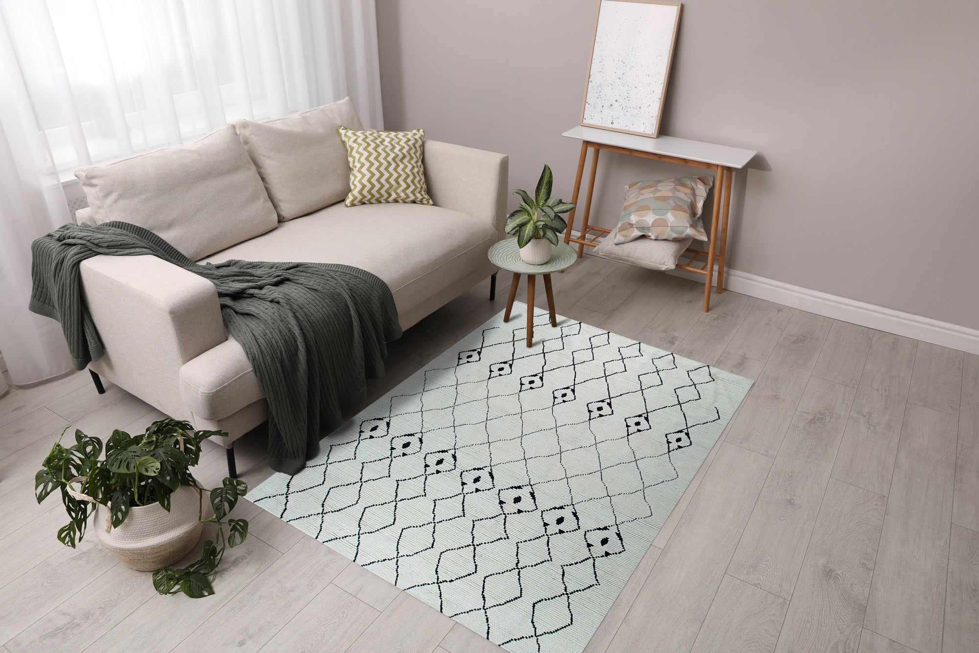 Rhea Diamond Ivory Hand Knotted Wool Rug, blending seamlessly into a bright living room. Neutral furniture complements the rug&#39;s diamond pattern, showcasing its soft, wool texture.