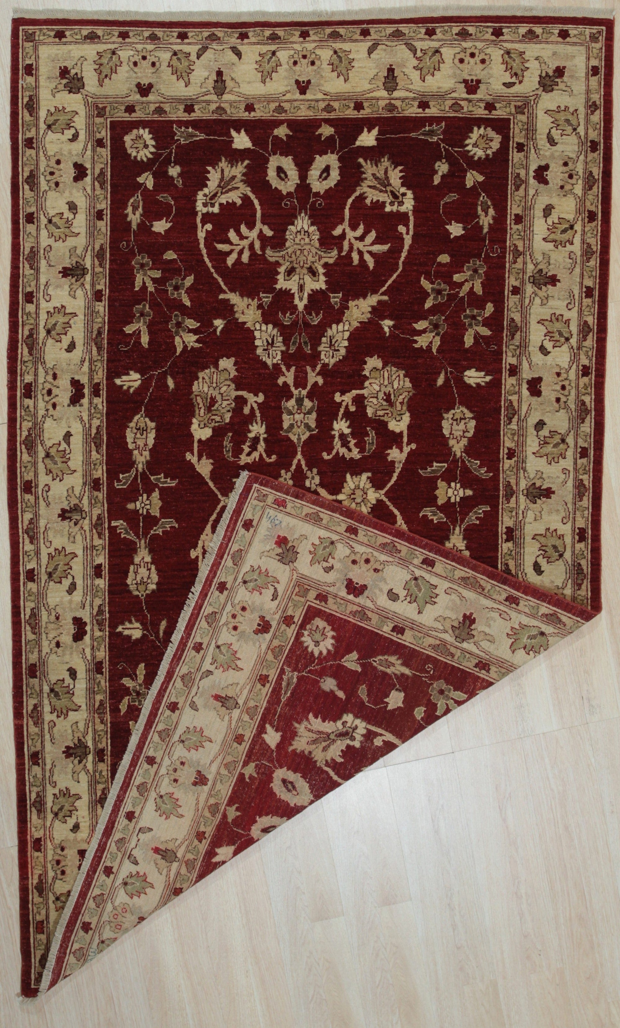 Rustic Agra Red Hand Knotted Wool Rug displayed in a room setting, its vibrant red hues and intricate hand-knotted wool construction adding warmth and texture to the space.