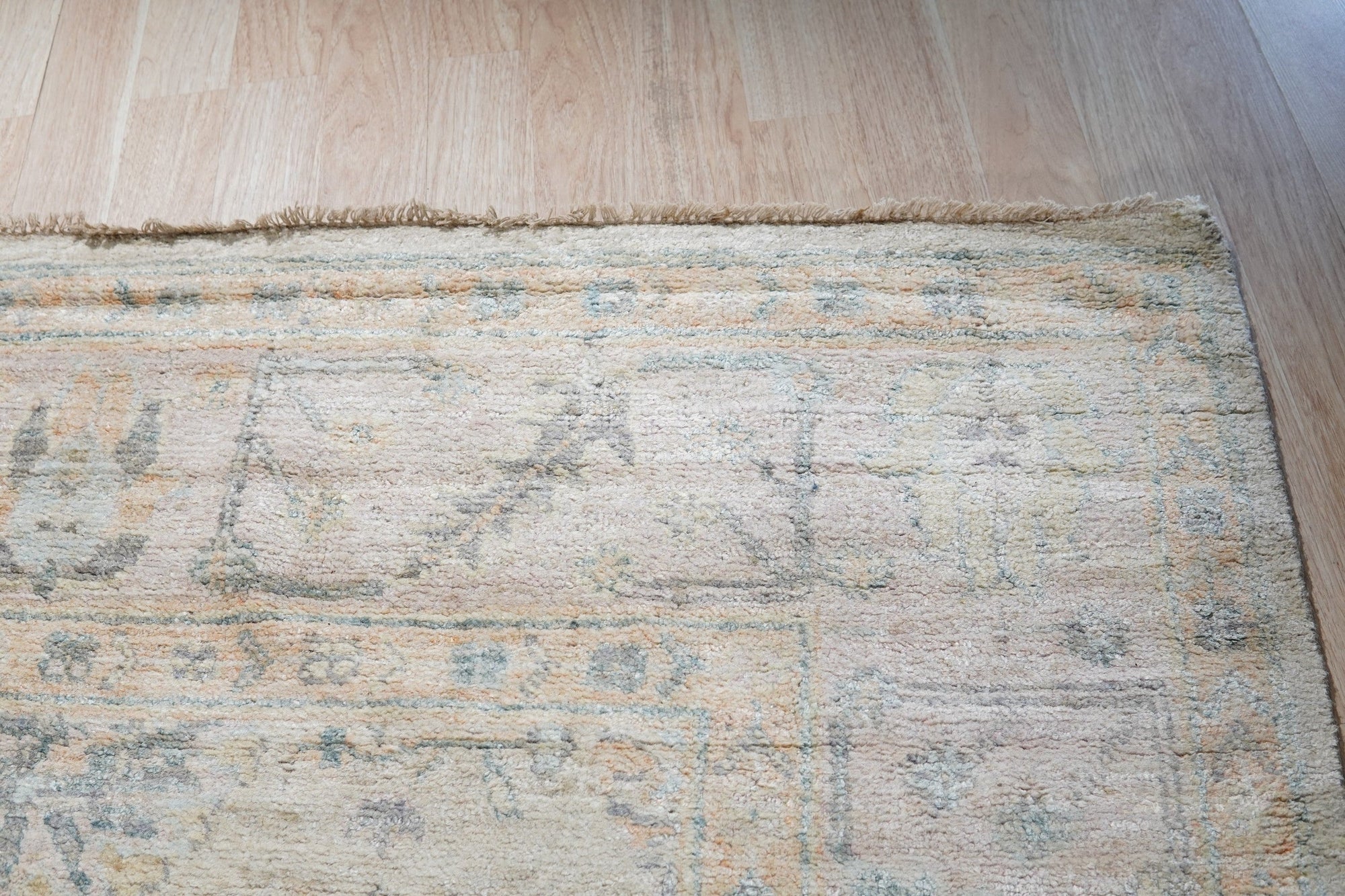 Elena Trara Ivory Hand Knotted Silk Rug, seen in a room setting, exemplifies luxurious floor covering with its subtle ivory tones and hand-knotted construction.