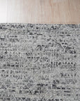 Refined Exquisite Gray Hand Knotted Silk Rug, its subtle sheen and intricate knotting displayed, rests on a hardwood floor, offering a luxurious and elegant texture.