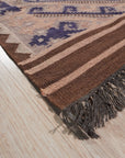 Penelope Jade Brown Flatweave Wool Rug, a blend of warm browns and subtle jade tones in a flatweave construction, displayed in a modern living room setting.